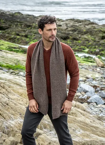 Personalized cashmere wool scarf in hazel brown, made in Ireland, styled with rust sweater and coastal backdrop